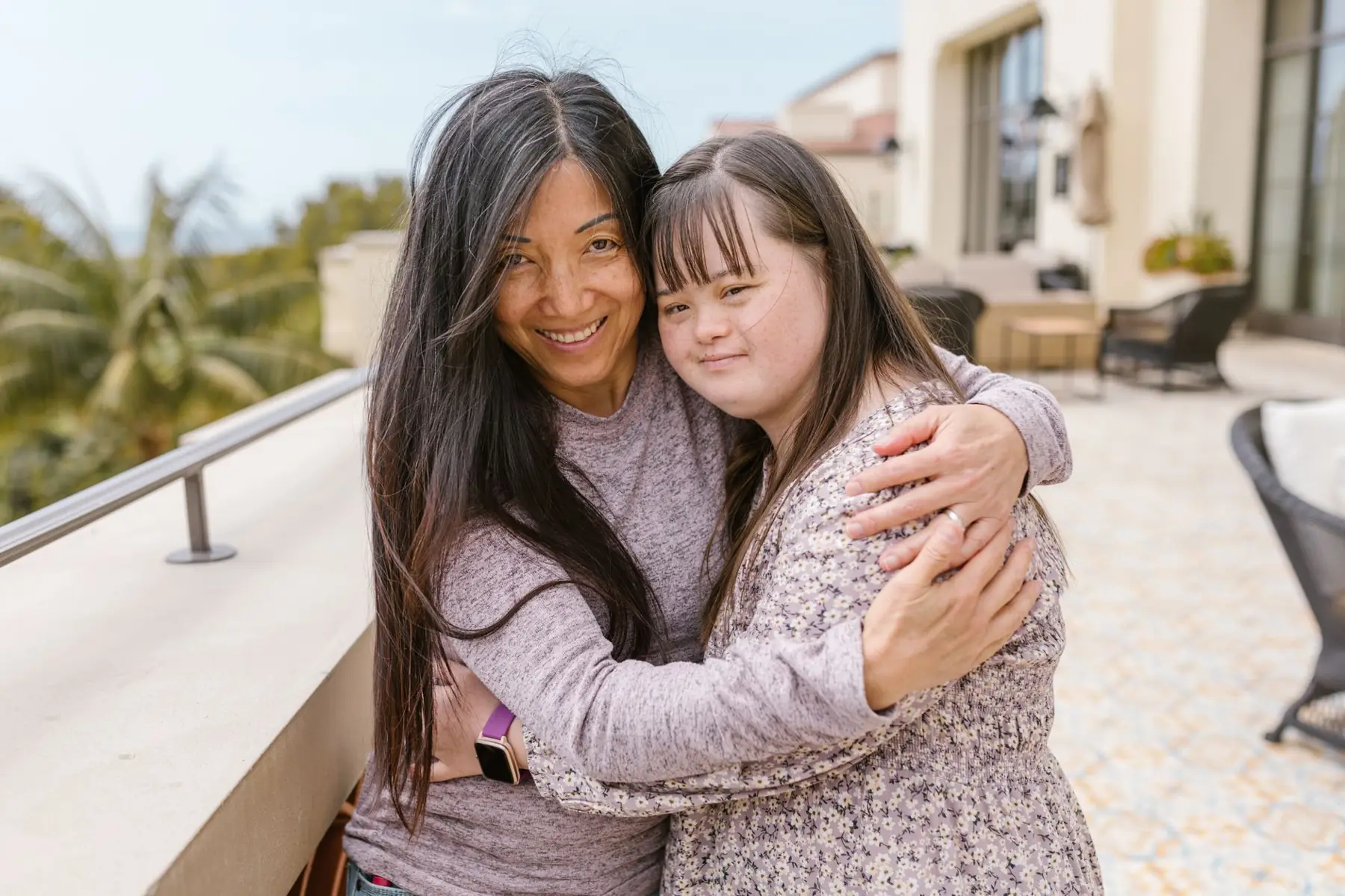 Una mamá abraza a su hija sonriendo